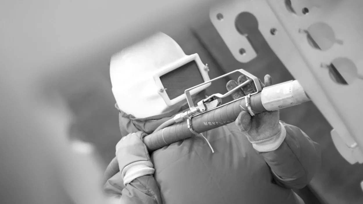 CYM Materiales pressurized blast pot systems Operator in full protective gear performing manual air blast shot blasting with CYM Materiales blast pot system